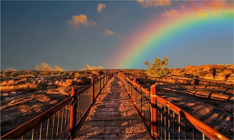 outdoor walkway with rainbow across the sky